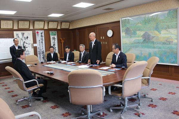 応接室にて会議テーブルを囲み座っている関係者と市長が立ってお話をしている写真