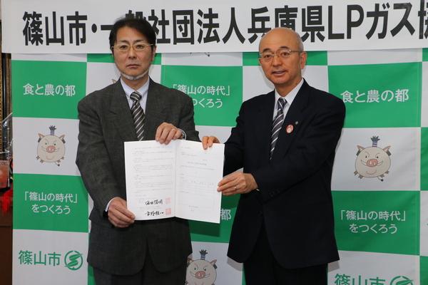 LPガス協会の支部長と締結された書類を手に持ち一緒にみせている市長の写真
