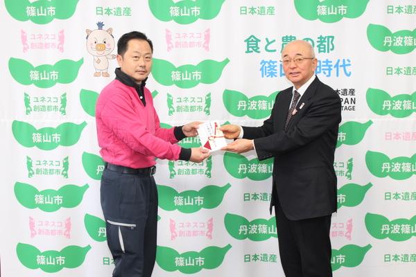 市長から選手へ奨励金を手渡している写真