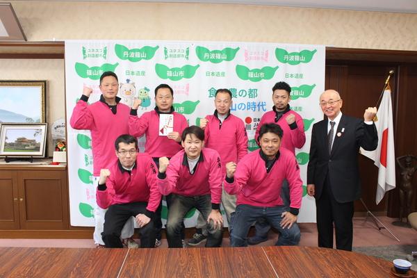 市長と7名の選手がガッツポーズをして写っている写真