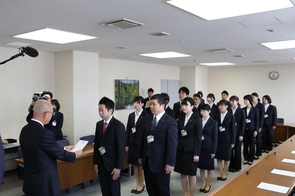 15名の新規職員が縦2列に並び市長の話しを聞いている写真
