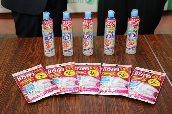 机の上に細長い5本の虫よけミストとその前に四角い袋に入った防菌マスクが5袋並べられている写真