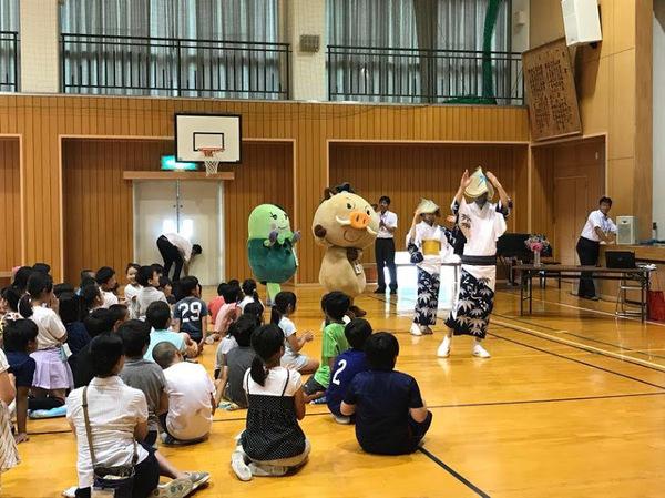 子供達の前で浴衣を着た方とマスコットキャラクターが一緒に踊っている写真