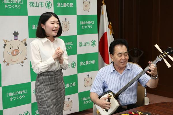 師匠の山口先生が三味線を弾き隣で小林さんが歌っている写真