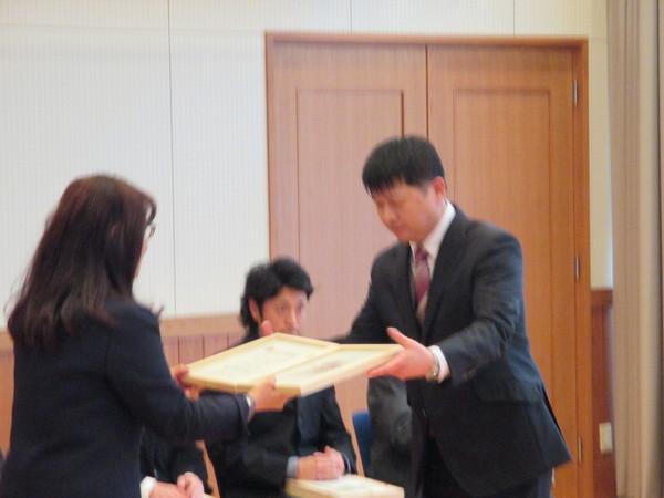 男性の方が女性から賞状を受け取ろうとする写真