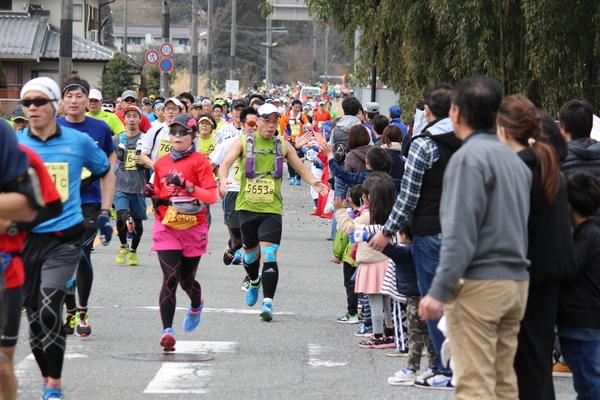 多くのランナーが走っていて、応援者と握手している写真