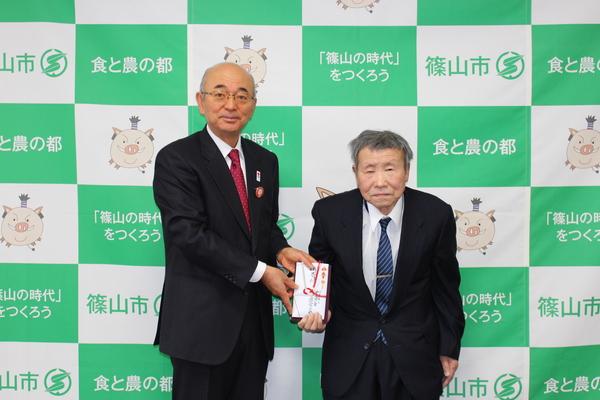 二階堂さんからいただいた寄付金を市長と二階堂さんの2人で持って写っている写真