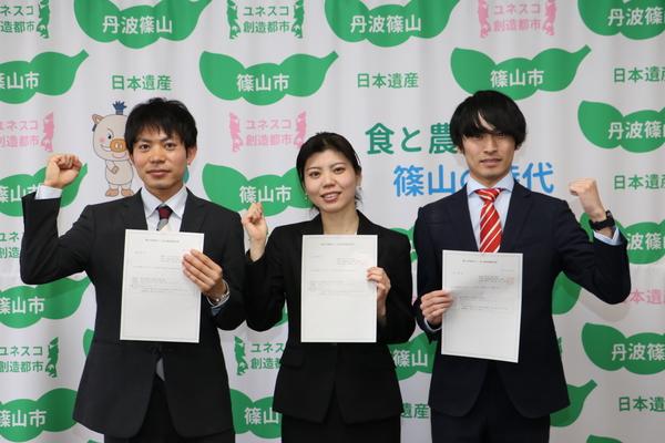 委託状を手にガッツポーズをする、児島さん、谷木さん、花谷さんの写真