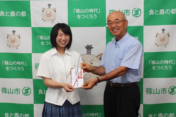 竹見さんと市長が目録を持って記念撮影をしている写真