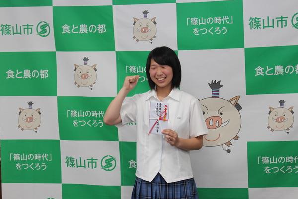 竹見さんが目録を片手にガッツポーズをしている写真