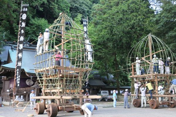 神社にて2台のキュウリ山を製作している人々の写真