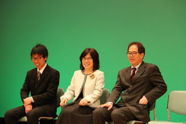 眼鏡の男性2人と女性が椅子に座って、笑っている写真