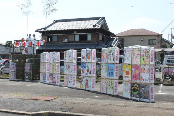 小学生の書いた30個ほどの灯篭が飾られている祭り会場の写真