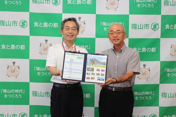 篠山のオリジナルフレーム切手を市長と郵便局の方とPRしている写真