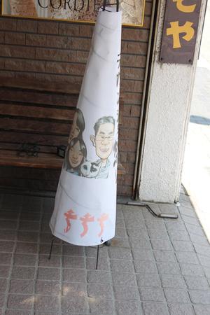 店先で3人家族が描かれたあんどんが置いてある写真