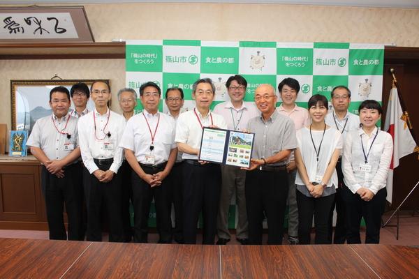 市長と皆さんで篠山のオリジナルフレーム切手持って撮影している写真