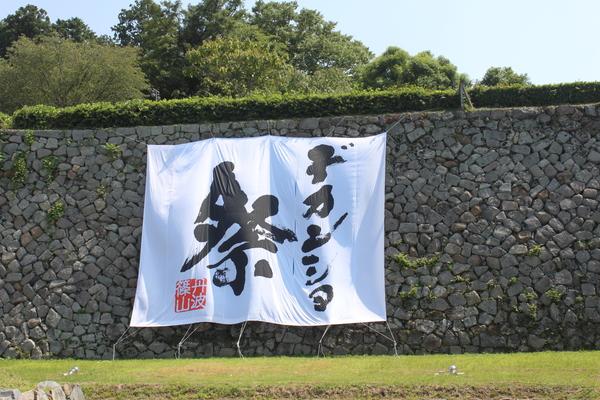 石垣にデカンショ祭りと書かれた大きな幕が飾られている写真