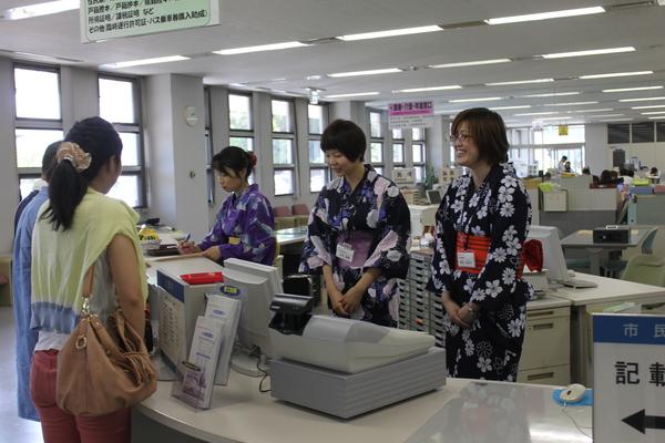 市役所で浴衣を着た3名の女性職員が受付をしている写真