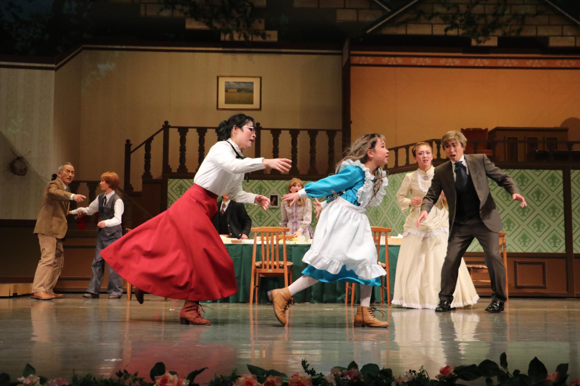 部屋の中を走って逃げるヘレンと、それを追いかけるサリバン先生。その光景を慌てた様子で見ているヘレンの父母らしき人々の写真