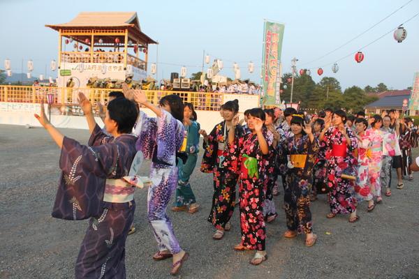 色鮮やかな浴衣を着た女性達が手を上げて踊っている写真
