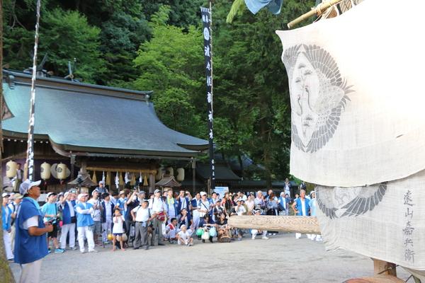 神社にてキュウリ山の前に人が集まっている写真