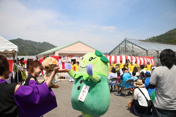 篠山市のマスコット人形の「まめりん」が女性と向き合って踊っている写真