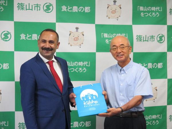 市長とキュタフヤ市長が紙袋を二人で持って並んでいる写真