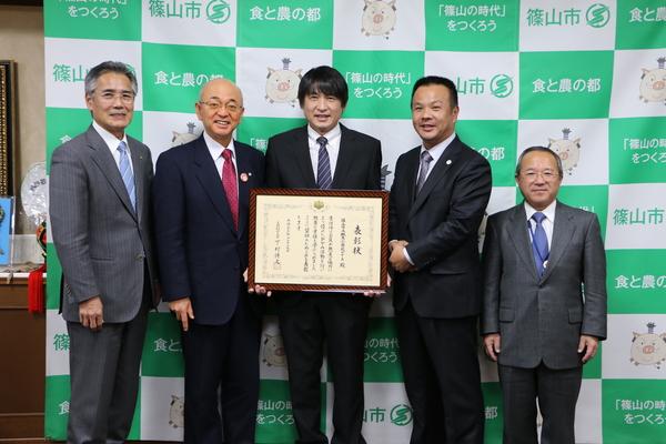 市長と城東小学校PTAの皆さんが「優良PTA文部科学大臣表彰状」を持って記念写真