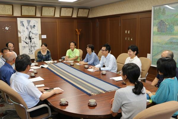 市長室の机で市長を囲んで避難者の方々がお話ししている写真