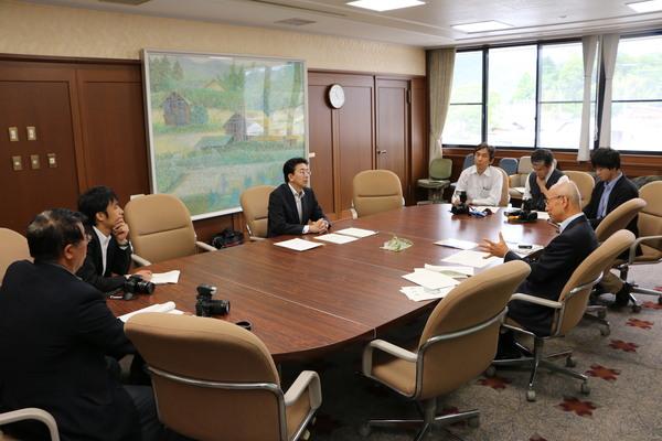 応接室にて、会議テーブルに座る市長と、6名の男性の写真