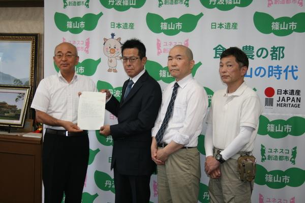 市長が篠山商店街連合会の方達と一緒に書類を手に持ち写っている写真
