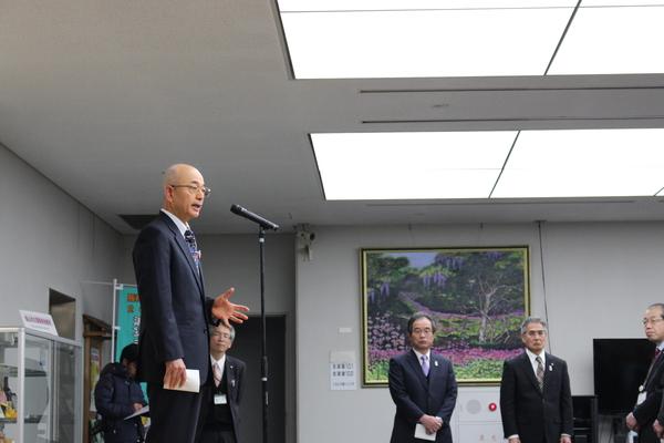 周りに職員が立っていて、市長がスタンドマイクで話をしている写真