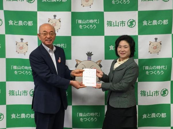 酒井市長と井上 友香さんが向かい合って2人で任命書を持ってこちらに見せている写真