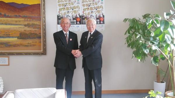 市長と井戸知事が両手で握手をして記念撮影している写真