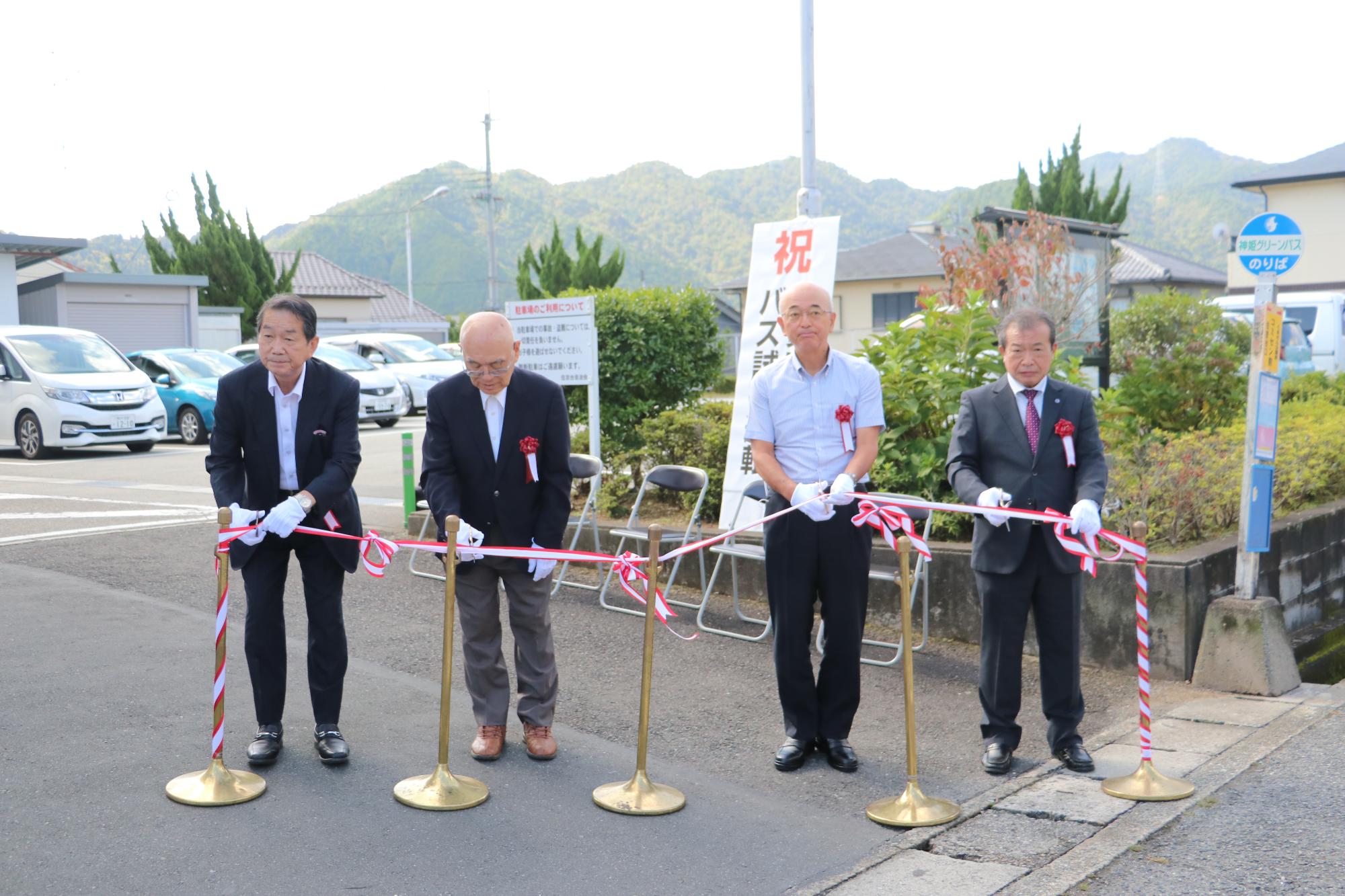 4人がバス新ルート出発のためのテープカットをしている