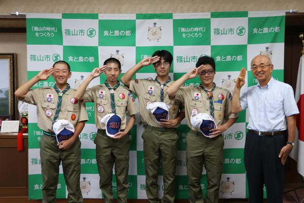 日本ボーイスカウト篠山第一団の制服を着て敬礼をした川上君、畑くん、北山君、渡海君、市長で記念写真