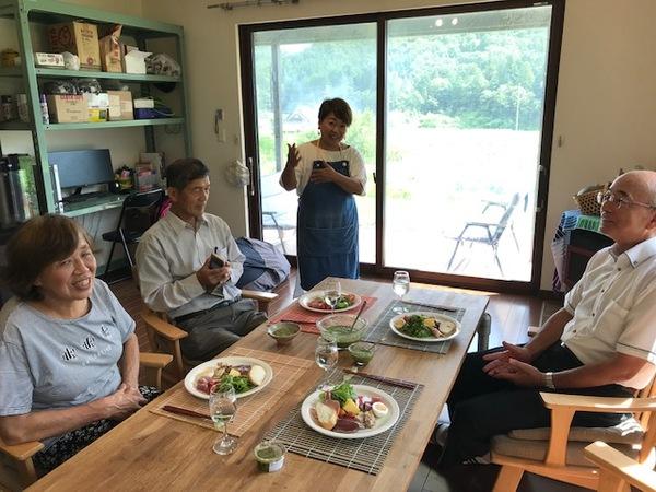 エプロン姿の井上さんが料理を前に市長らに説明をしている写真