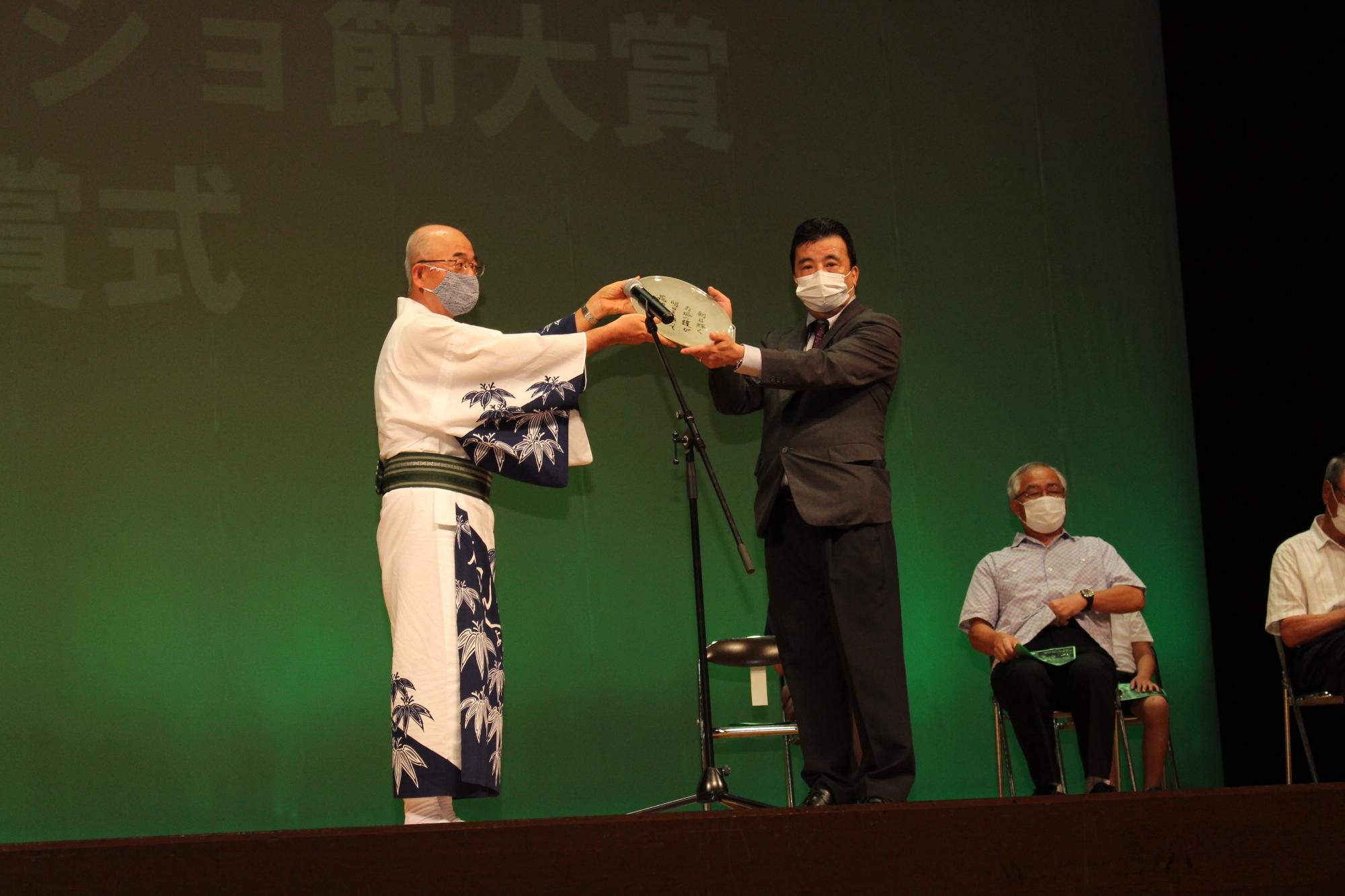 副賞の丹波焼の大皿を、酒井市長が受賞者に渡している