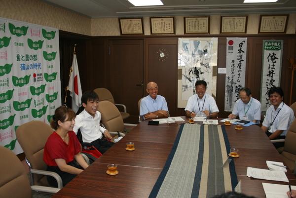 西井 拓海さんの隣に女性が座り、市長たちと和やかにお話ししている写真