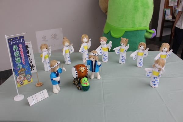 太鼓を叩く青色の法被を着た人形2体と、笹の絵が描かれた白い浴衣を着たデカンショを踊っている8体の人形の写真