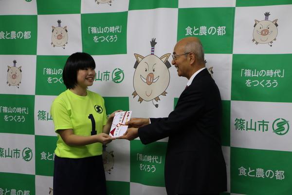 「Colorsささやま」の代表選手が市長から「丹波篠山ふるさとPR奨励金」を手渡しで受け取っている写真