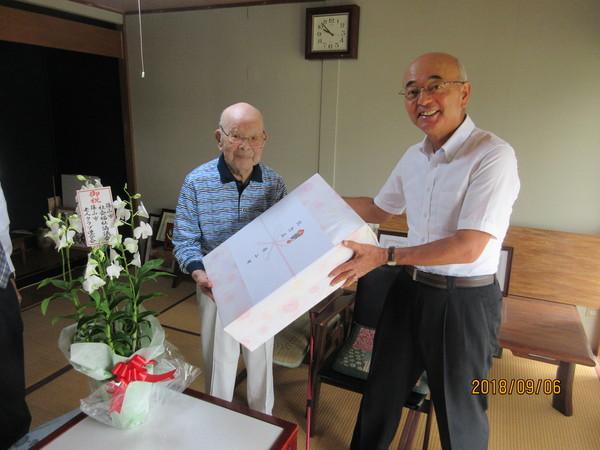市長が長寿御祝の訪問の際に波部時雄さん(102歳)へ御祝の花と記念品を贈呈している写真