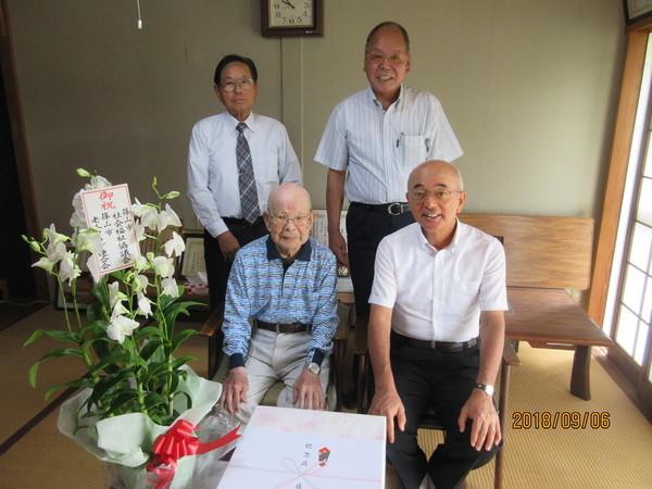 波部時雄さん(102歳)が市長らと長寿御祝の花と記念品を前に記念撮影している写真