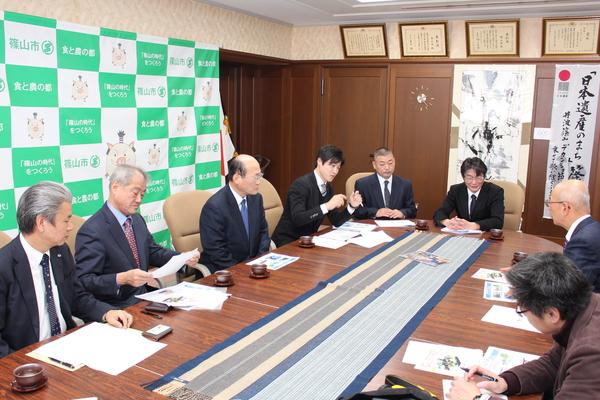 市長室にて、市長の前に舞鶴若狭自動車道 西紀サービスエリア上り線アイランドフューチャーコーポレーション株式会社の関係者の皆さんが座っており、市長が報告を受けている様子の写真