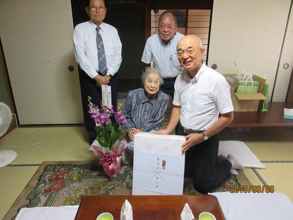 市長が長寿御祝の訪問の際に小林ふみ子さん(102歳)へ御祝の花と記念品を前に記念撮影している写真