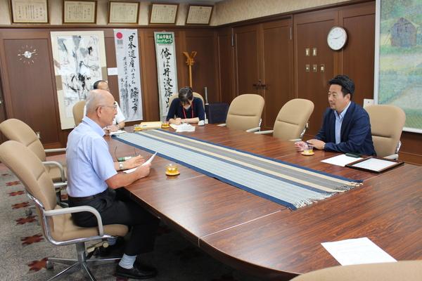 市長と丹波篠山たけし農産の中島さんが話をしているのを職員が書記している写真