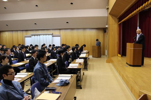 壇上で市長が話をしているのを、着席して聞いている男女の写真