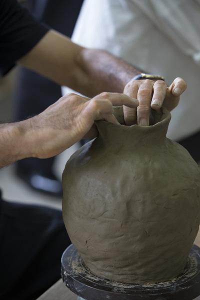 素焼き前のつぼの上の部分を手で形づくっている写真