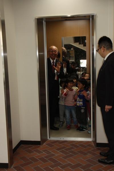 エレベーターの中にいる、小さい子供たちと、手を振る市長の写真