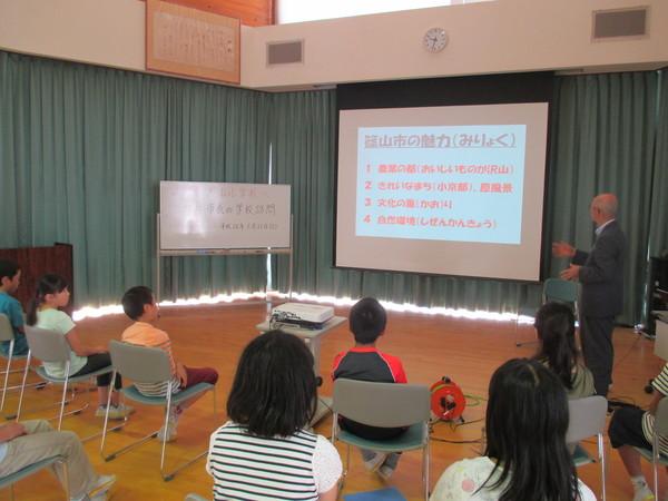 市長が子供達にスクリーンを使って「篠山市の魅力」を説明している写真